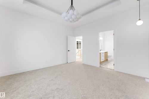 This room features light-colored patterned carpet and white walls - 4004 35 Street, Beaumont, AB - Indoor Photo Showing Other Room