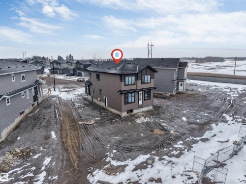 This property features a two-story design with dark siding and multiple windows - 4004 35 Street, Beaumont, AB - Outdoor With View