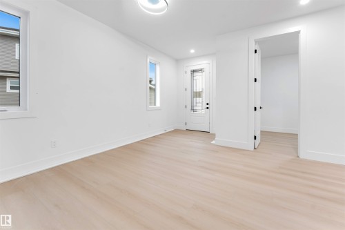 Entryway featuring light-colored flooring, white walls, and a front door with decorative glass inserts - 4004 35 Street, Beaumont, AB - Indoor Photo Showing Other Room