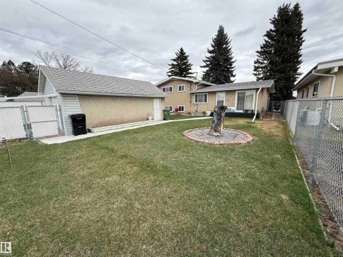Expansive green space featuring a chain-link fence, mature trees, and a detached structure with a pitched roof - 12916 95A Street, Edmonton, AB - Outdoor