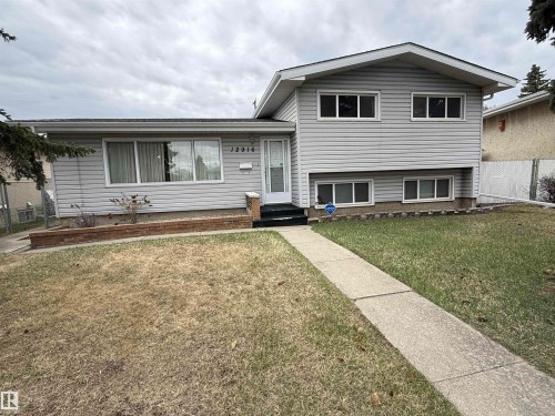 Split-level residence featuring light-colored siding, a front entry with a white door, and multiple windows - 12916 95A Street, Edmonton, AB - Outdoor