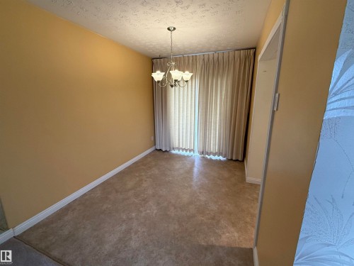 Interior room featuring neutral-toned walls, textured ceiling, and light-colored carpeting - 12916 95A Street, Edmonton, AB - Indoor Photo Showing Other Room