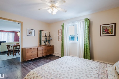 The room features dark wood flooring and a ceiling fan - 25 9926 80 Avenue, Edmonton, AB - Indoor Photo Showing Bedroom
