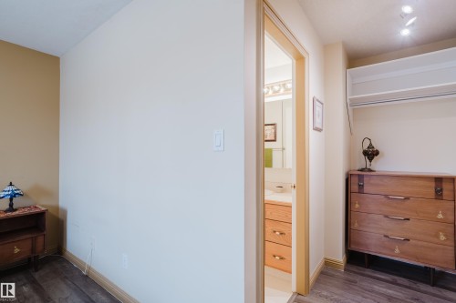 This interior space features light-colored walls and dark wood flooring - 25 9926 80 Avenue, Edmonton, AB - Indoor