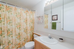 This bathroom features a vanity with an integrated sink, a large mirror, and a toilet - 