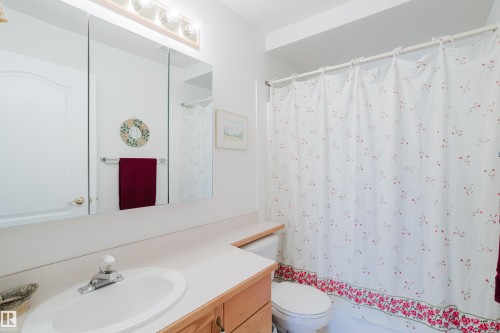 Bathroom featuring a light wood vanity with a white countertop and an integrated sink - 25 9926 80 Avenue, Edmonton, AB - Indoor Photo Showing Bathroom