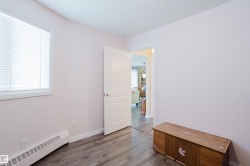 This room features a window with blinds, baseboard heating, and wood-style flooring - 