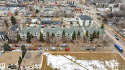 Aerial view of the neighborhood showing a multi-story residential building with balconies and trees lining the street - 