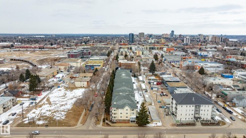 The property offers an aerial view of a vibrant urban landscape, featuring various buildings and distant city skyline - 25 9926 80 Avenue, Edmonton, AB - Outdoor With View