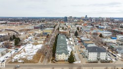 The property offers an aerial view of a vibrant urban landscape, featuring various buildings and distant city skyline - 