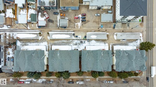 Aerial view showcasing a row of properties with pitched roofs, fronting a street lined with trees and parked vehicles - 25 9926 80 Avenue, Edmonton, AB - Other