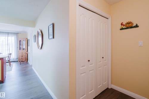 This interior space features light-colored walls and dark wood flooring - 25 9926 80 Avenue, Edmonton, AB - Indoor Photo Showing Other Room