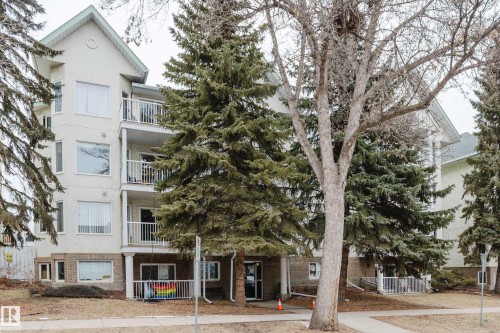 The property features a multi-story building with a light-colored exterior and multiple balconies, each with metal railings - 25 9926 80 Avenue, Edmonton, AB - Outdoor With Balcony With Facade