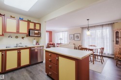 The kitchen features wood-look flooring, a stainless steel dishwasher, and a built-in microwave - 