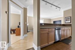 Kitchen featuring wood-finish cabinetry, stainless steel dishwasher, and track lighting - 