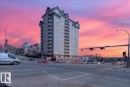 Multi-story building featuring numerous private balconies, a distinctive roofline with dormer-like structures, and a stone-clad base - 701 9707 105 Street, Edmonton, AB  - Outdoor With Facade 