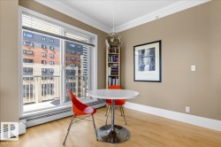 Sliding glass doors leading to a balcony, light wood-finish flooring, built-in shelving, crown molding, and neutral wall tones - 