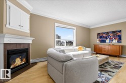 Living room featuring a fireplace with a tiled surround, a white mantel, and built-in cabinetry above - 
