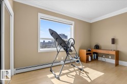 Bright room featuring wood-finish flooring, a large window, and crown molding - 