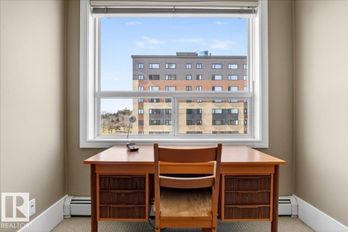 Bright room with a large window, tan painted walls, white baseboards, and carpeted flooring - 701 9707 105 Street, Edmonton, AB - Indoor Photo Showing Office