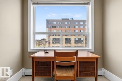 Bright room with a large window, tan painted walls, white baseboards, and carpeted flooring - 