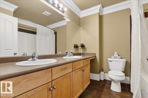 Double vanity with dual basins, light wood-finish cabinetry, and neutral countertops - 701 9707 105 Street, Edmonton, AB - Indoor Photo Showing Bathroom