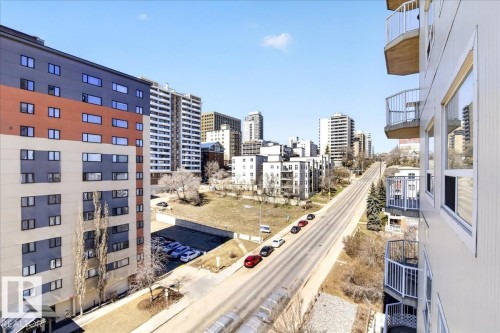 Urban streetscape featuring a paved road, multi-story buildings, and visible parking areas - 701 9707 105 Street, Edmonton, AB - Outdoor