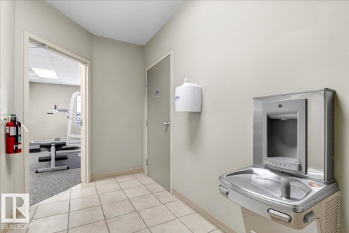 Hallway featuring light neutral wall paint and a recessed wall-mounted water fountain - 701 9707 105 Street, Edmonton, AB - Indoor Photo Showing Bathroom