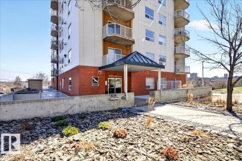 Multi-story building featuring brick and panel exterior, multiple balconies with white railings, and a covered main entrance - 701 9707 105 Street, Edmonton, AB - Outdoor With Balcony