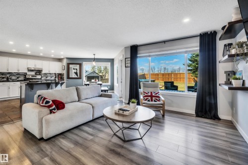 Open-concept living space featuring wood-finish flooring, recessed lighting, and a large picture window - 96 Bonin Crescent, Beaumont, AB - Indoor Photo Showing Living Room
