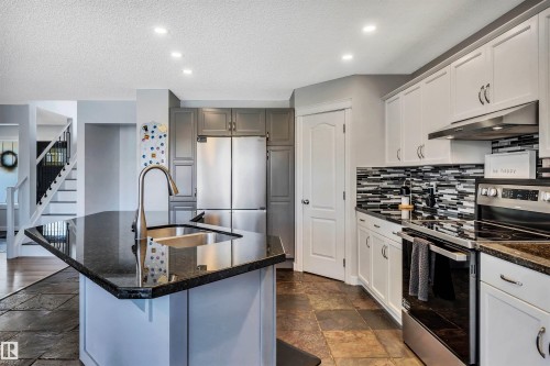 Kitchen featuring granite countertops, stainless steel appliances, a tile backsplash, recessed lighting, and slate tile flooring - 96 Bonin Crescent, Beaumont, AB - Indoor Photo Showing Kitchen With Double Sink With Upgraded Kitchen