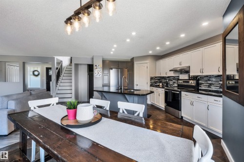 Open-concept living area featuring a kitchen with stainless steel appliances, a center island, and a black and white tile backsplash - 96 Bonin Crescent, Beaumont, AB - Indoor
