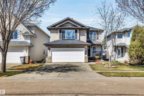 Two-story residence featuring light-toned siding, a dark shingle roof, and a prominent attached two-car garage - 96 Bonin Crescent, Beaumont, AB - Outdoor With Facade
