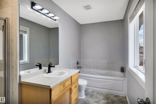 Bathroom featuring a single vanity with a white countertop, matte black faucet, and matching light fixture - 96 Bonin Crescent, Beaumont, AB - Indoor Photo Showing Bathroom