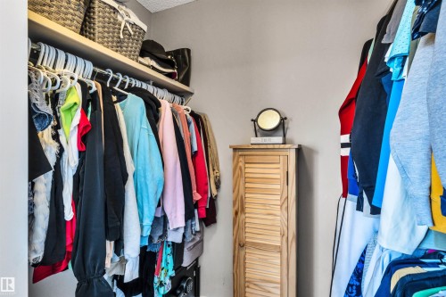 Spacious closet featuring built-in shelving, a hanging rod system, light-toned walls, and a louvered cabinet - 96 Bonin Crescent, Beaumont, AB - Indoor With Storage