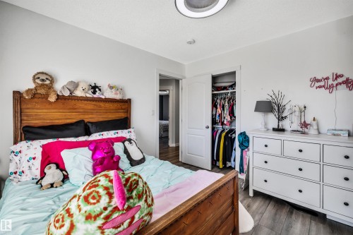 Bedroom featuring wood-finish flooring, white walls, and a built-in closet with double doors - 96 Bonin Crescent, Beaumont, AB - Indoor Photo Showing Bedroom