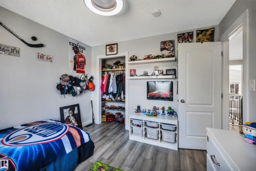 Room featuring wood-finish flooring, a built-in closet with shelving and hanging space, and a ceiling-mounted light fixture - 96 Bonin Crescent, Beaumont, AB - Indoor Photo Showing Bedroom