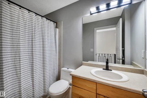 Bathroom vanity featuring a light-toned countertop, oval undermount sink, and a matte black faucet - 96 Bonin Crescent, Beaumont, AB - Indoor Photo Showing Bathroom