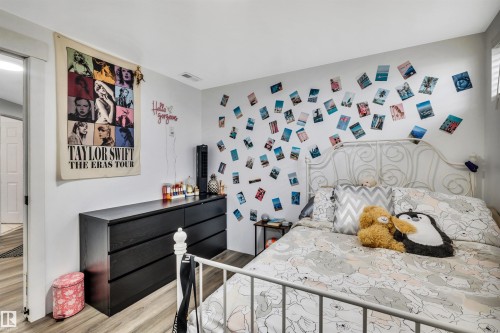 Light gray wall finishes and wood-finish flooring - 96 Bonin Crescent, Beaumont, AB - Indoor Photo Showing Bedroom