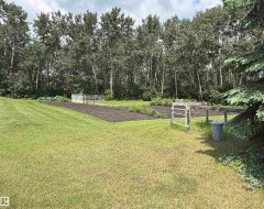Expansive yard featuring a large tilled garden bed and green lawn - 