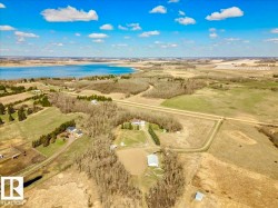 Expansive rural property featuring multiple structures, a large barn, and a horse training ring - 
