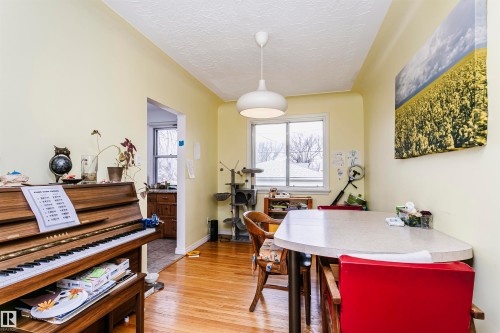 Dining area featuring wood-finish flooring and a contemporary pendant light fixture - 9760 64 Avenue, Edmonton, AB - Indoor Photo Showing Dining Room