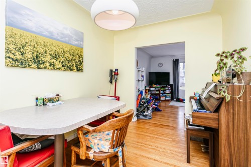 Dining area featuring light yellow walls and a contemporary ceiling light fixture - 9760 64 Avenue, Edmonton, AB - Indoor Photo Showing Dining Room