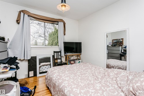 Hardwood flooring and bright white walls - 9760 64 Avenue, Edmonton, AB - Indoor Photo Showing Bedroom