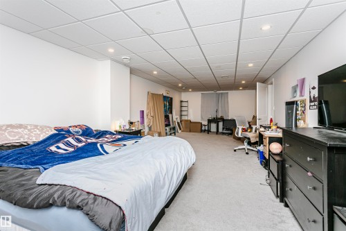 Expansive room featuring light-colored carpeting, white painted walls, and a drop ceiling with recessed lighting - 9760 64 Avenue, Edmonton, AB - Indoor Photo Showing Bedroom