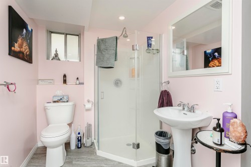 Bathroom featuring a corner glass-enclosed shower, pedestal sink, and a mirrored medicine cabinet - 9760 64 Avenue, Edmonton, AB - Indoor Photo Showing Bathroom