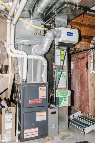 Goodman furnace system with extensive ductwork, integrated humidifier, and exposed wood joist ceiling - 9760 64 Avenue, Edmonton, AB - Indoor Photo Showing Basement