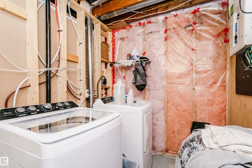 Unfinished utility space featuring exposed wooden studs, visible plumbing, and electrical conduits - 9760 64 Avenue, Edmonton, AB - Indoor Photo Showing Laundry Room