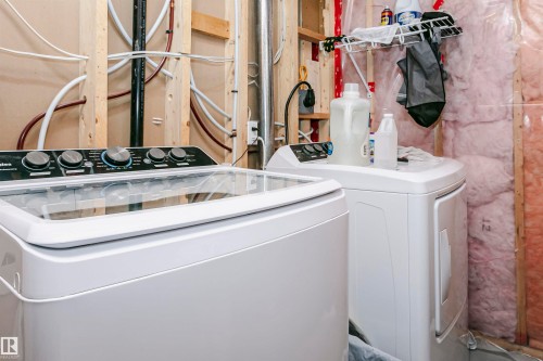Dedicated laundry area featuring a white top-load washing machine and a white front-load dryer - 9760 64 Avenue, Edmonton, AB - Indoor Photo Showing Laundry Room
