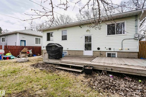 Rear exterior featuring white vinyl siding, multiple windows, and a wooden deck with steps - 9760 64 Avenue, Edmonton, AB - Outdoor With Deck Patio Veranda With Exterior